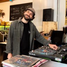 Patrick grinst vor den Turntables in seinem Wiesabadener Cafe