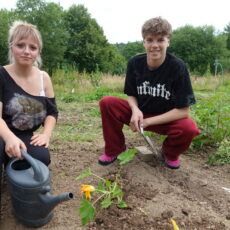 Freyda & Tobias beim pflanzen von Zucchini auf dem Schulacker.