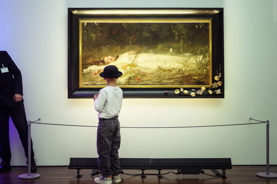 Das Gemälde Ophelia ist zu sehen. Davor steht ein Betrachter und blickt darauf.